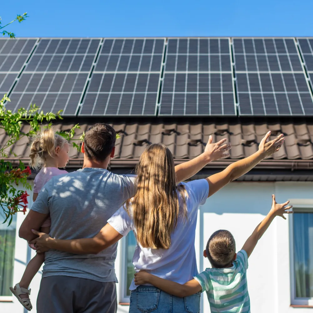 A family outside a home with roof mounted solar panels